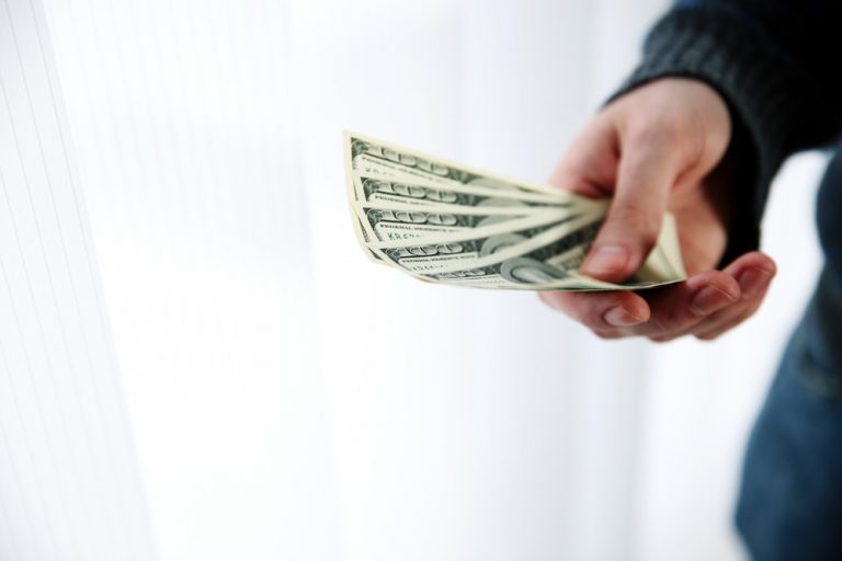 Closeup portrait of a male hand giving money